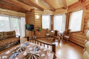 a bedroom in a log cabin with a bed and a couch at Gostynniy Dvir Raytshtoky in Vorokhta