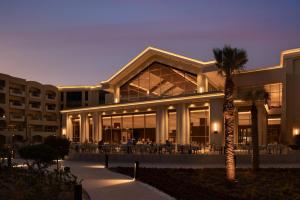 a building with a palm tree in front of it at SRNTY Sahl Hasheesh - Ex Serenity Sky Arc in Hurghada