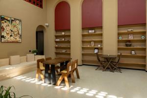 a dining room with a table and chairs and shelves at Qinxiang Pavilion Hotel in Dunhuang