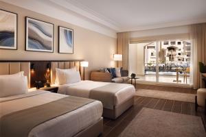 a hotel room with two beds and a couch at SRNTY Sahl Hasheesh - Ex Serenity Sky Arc in Hurghada +43 photos