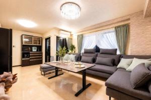 a living room with a couch and a table at HOTEL StayLuck MARUGAME - 無料駐車場 in Marugame