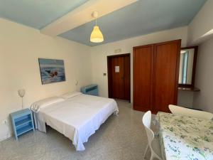 ein Schlafzimmer mit einem weißen Bett und einem Tisch in der Unterkunft Blu Mare in Ponza