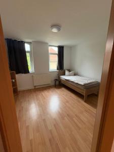 an empty room with a bed and two windows at Apartment Zeitz Zangenberg groß in Zeitz