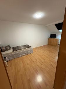 an empty room with a bed and a wooden floor at Apartment Zeitz Zangenberg groß in Zeitz