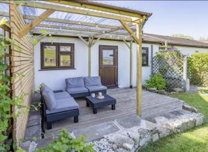 a wooden patio with a couch and a table at Blaen Cedi Holiday Cottages in Swansea