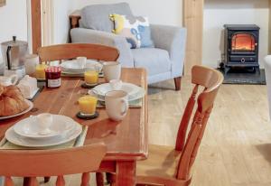 a living room with a table and chairs with a table and a fireplace at Blaen Cedi Holiday Cottages in Swansea