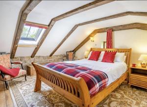 a bedroom with a large bed and a chair at Blaen Cedi Holiday Cottages in Swansea