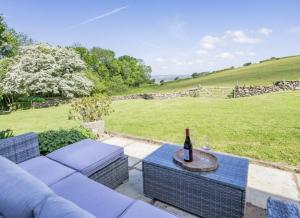 a bottle of wine sitting on top of a couch at Blaen Cedi Holiday Cottages in Swansea