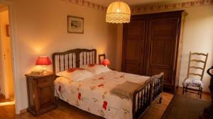 a bedroom with a bed and two lamps and a chandelier at Vaste et confortable maison à la campagne in Villotte-sur-Aire