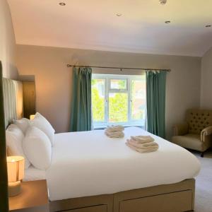 a bedroom with a large white bed with a window at Hotel Wrexham in Wrexham