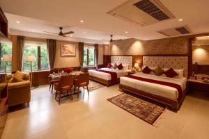 a hotel room with two beds and a dining room at Gopuram Grand in Madurai