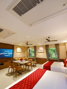 a hotel room with two beds and a dining room at Gopuram Grand in Madurai