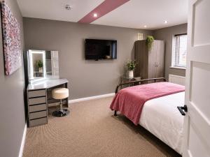 a bedroom with a bed and a desk and a television at Chester Charm - Spacious 3 Bedroom House in Chester