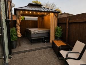 a patio with a bed and a gazebo with lights at Chester Charm - Spacious 3 Bedroom House in Chester