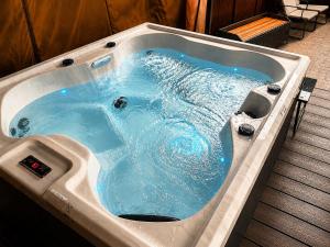 a jacuzzi tub with blue water in it at Chester Charm - Spacious 3 Bedroom House in Chester +15 photos