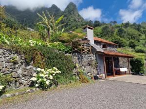 a stone house with a cross on the side of it at Zef's Cottage in São Vicente