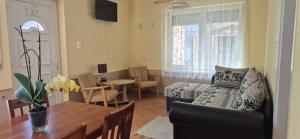 a living room with a couch and a table at Bazsarózsa Apartmanok Csopak in Csopak