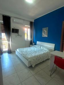 a bedroom with a bed with a blue wall at Lincoln B&B in Caserta +16 photos