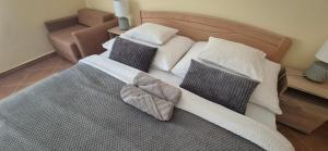 a bedroom with a bed with two pillows on it at Bazsarózsa Apartmanok Csopak in Csopak