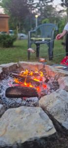 a person is cooking food on a grill at Bazsarózsa Apartmanok Csopak in Csopak
