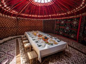 a long table in a room with a red ceiling at Ночлег с завтраком in Dzhangyaryk