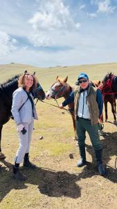 a man and a woman standing next to a horse at Ночлег с завтраком in Dzhangyaryk
