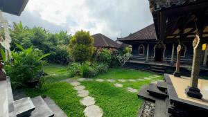 a garden with grass and rocks in front of a house at JERO Tabola 2 in Sidemen