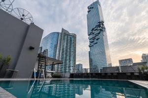 a view of a tall building and a swimming pool at Sora Hotel Silom in Bangkok