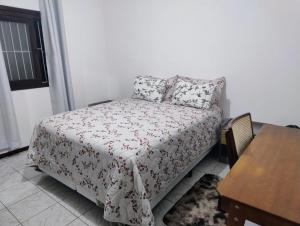a small bedroom with a bed and a table at casa top proximo Fenac NH in Novo Hamburgo