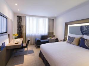 a hotel room with a large bed and a desk at Novotel Bangkok Bangna in Bangna