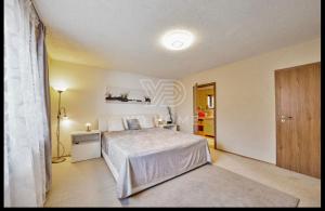 a bedroom with a bed and a table and a door at Wellness Villa close to Prague in Kuchař