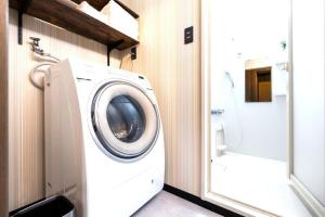 a washing machine in a bathroom next to a toilet at HOTEL StayLuck MARUGAME - 無料駐車場 in Marugame