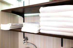 a pile of towels on a shelf in a bathroom at HOTEL StayLuck MARUGAME - 無料駐車場 in Marugame +25 photos