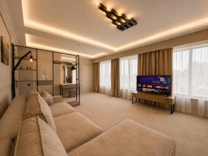a living room with a couch and a flat screen tv at Boomerang Boutique Hotel in Odesa