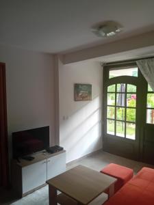 a living room with a couch and a table and a window at Apartman NeSa Boracko jezero in Konjic