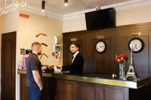 two men shaking hands at a counter in a bar at Boomerang Boutique Hotel in Odesa