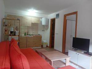 a living room with a red couch and a kitchen at Apartman NeSa Boracko jezero in Konjic