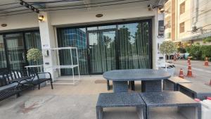a table and benches in front of a building at beMyGuest Bangsaen in Ban Thai Don (1)