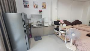 a kitchen with a refrigerator and a sink at beMyGuest Bangsaen in Ban Thai Don (1)