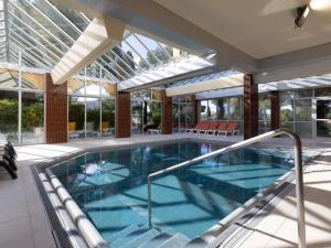 a swimming pool in a house with a glass ceiling at ibis Sète Balaruc les Bains Bien-être et Spa in Balaruc-les-Bains