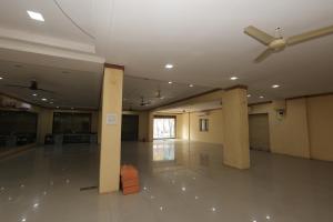 a large room with columns and a ceiling fan at Hotel Keshav Pride in Dhule
