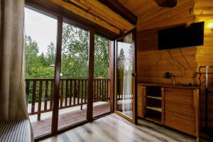 a screened in porch with a flat screen tv and sliding glass doors at Gostynniy Dvir Raytshtoky in Vorokhta