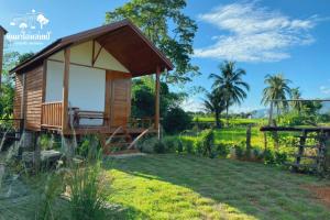 a small wooden cabin with a porch in a garden at หินผาปัว รีทรีต & หินผาโฮมสเตย์ in Ban Choko