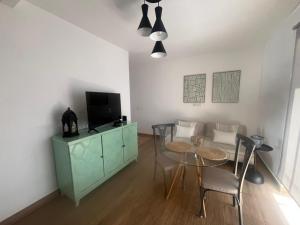 a living room with a table and chairs and a television at CASA del CHARCO 2,1 in Arrecife