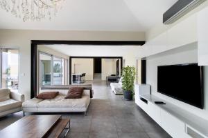 a living room with a couch and a tv at Villa Gecko avec piscine in Sari Solenzara
