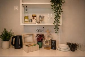 a kitchen counter with a shelf with dishes and a mirror at Prime Apartment Hotel in Nuremberg +10 photos