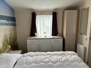 a bedroom with a bed and a sink and a window at ZeeGlück in Oostkapelle