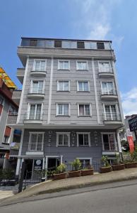 a tall gray building with windows on a street at Şahinler Suit Apart in Trabzon