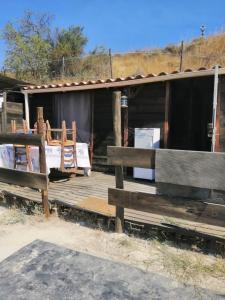 a wooden porch of a building with benches at Cabane insolite au sein d un ranch in Poilhès +11 photos