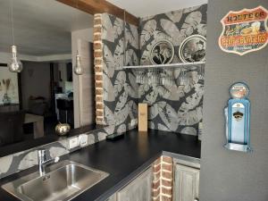 a kitchen with a sink and a wall with a mural at L'Éphém'Heer in Hastière-par-delà +48 photos